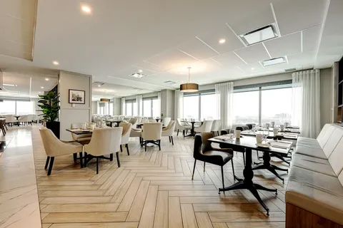 Dining room with set tables, upholstered chairs and large windows