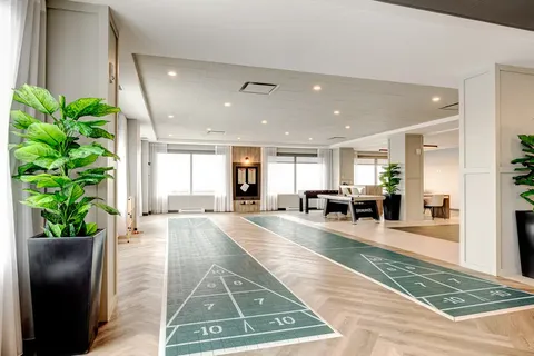 Indoor shuffleboard courts beside windows and pool tables