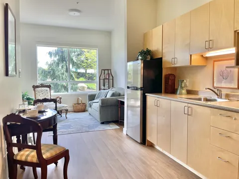 Suite kitchenette and sitting room beside large windows.