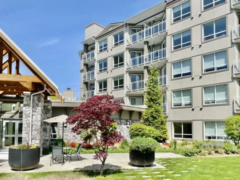 Multi-storey residence with balconies, a timber entrance and landscaped gardens.
