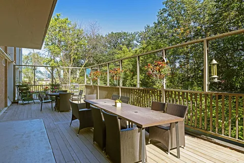 Covered terrace with tables and chairs beside trees