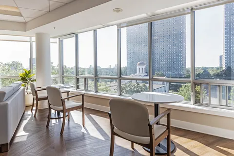 Tables and chairs beside floor-to-ceiling windows