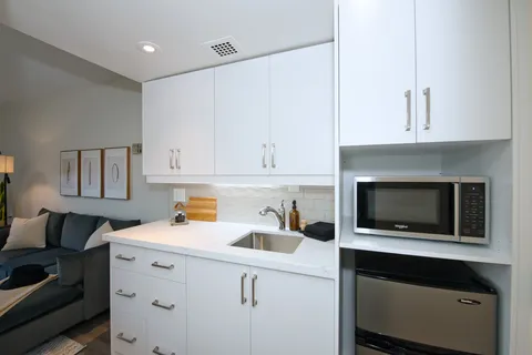 Suite kitchenette with white cabinets and appliances