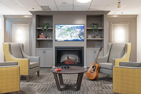Lounge with armchairs, a fireplace and a guitar