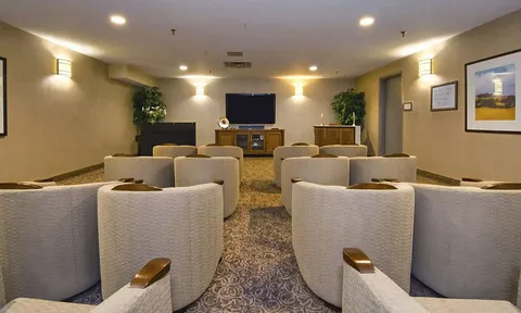 Theatre room with upholstered chairs facing a screen