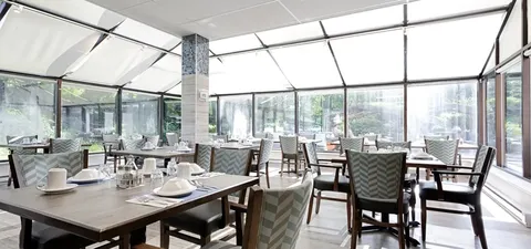 Dining room with set tables beneath a glazed roof