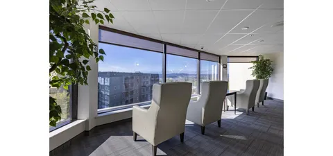 Armchairs beside large windows overlooking the city
