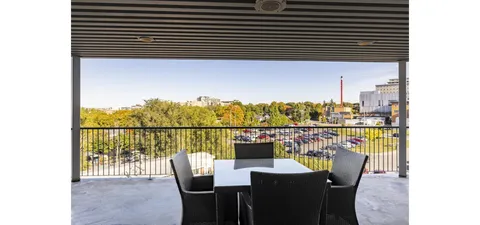 Covered terrace with tables and chairs overlooking trees