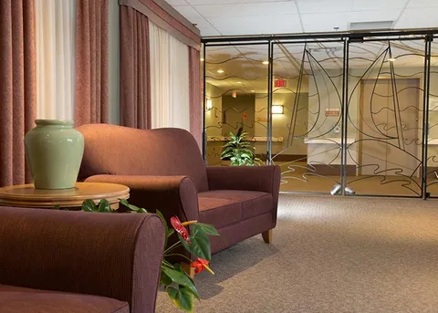 Window-side seating area with armchairs and glass partitions.
