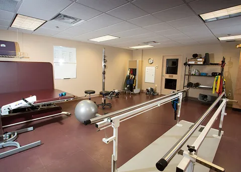 Exercise room with parallel bars and fitness equipment.