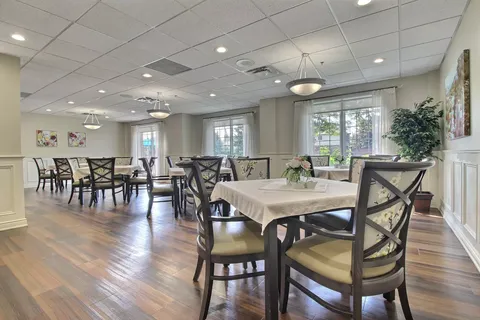 Dining room with tables, floral upholstered chairs and windows