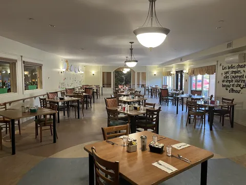Dining room with set tables, wooden chairs and pendant lights