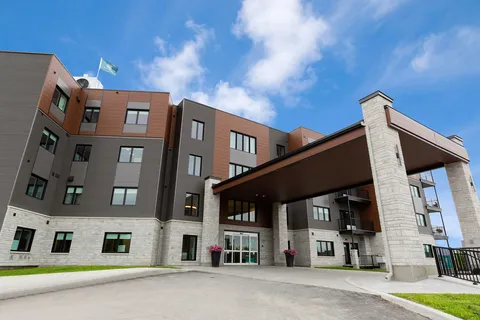 Aquatria building with a tall covered entrance and driveway.