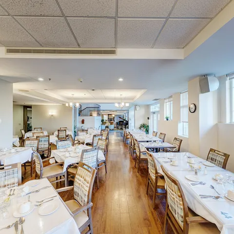 Dining room with set tables, wooden chairs and windows