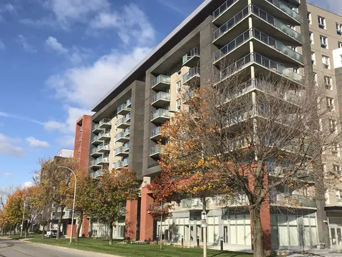Residence building with balconies and autumn trees beside a street