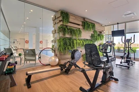 Fitness room with exercise machines, mirrors and hanging plants