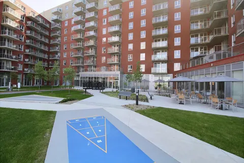 Residence wings around a courtyard with a lawn, shuffleboard and patio