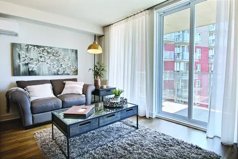 Sitting area with a sofa, glass coffee table and balcony doors