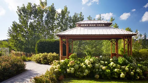 Garden path and flowering shrubs surrounding a wooden gazebo