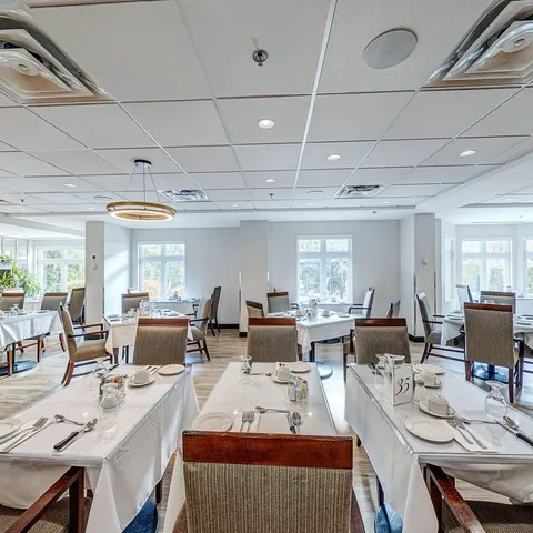 Dining room with set tables, upholstered chairs and windows