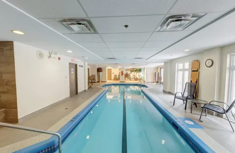 Indoor swimming pool with tiled surrounds and handrails