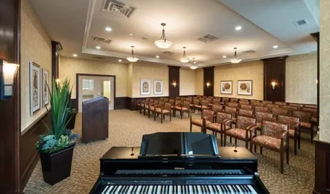 Rows of chairs facing a lectern with a piano in the foreground