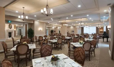 Dining room with round tables, upholstered chairs and chandeliers