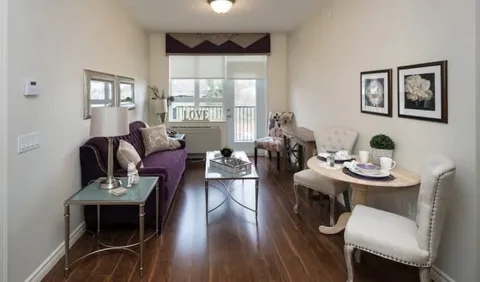 Suite sitting area with a purple sofa and a small table for two
