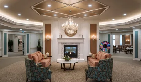 Armchairs around a fireplace beneath a chandelier