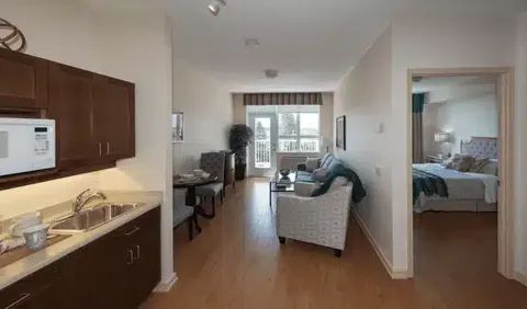 Kitchenette opening onto a sitting area beside a bedroom