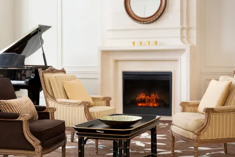 Lobby seating beside a fireplace and grand piano.