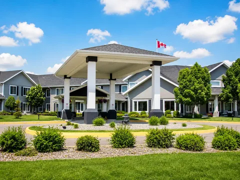 Residence building with a covered entrance and landscaped lawn.