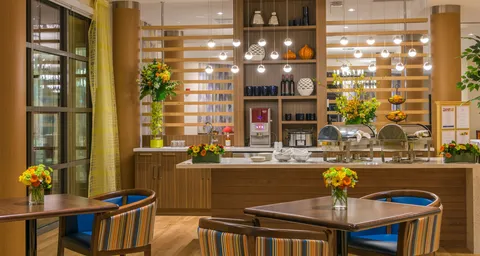 Bistro counter and tables with pendant lights and shelving.