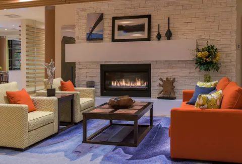 Fireside lounge with orange seating and a coffee table.