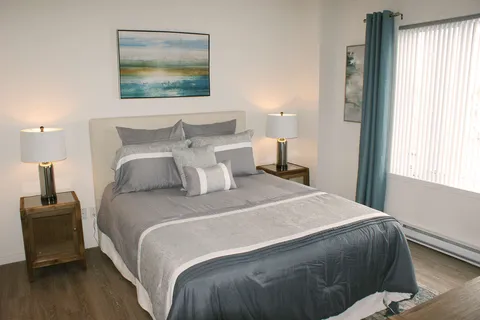 Bedroom with a double bed and large windows.
