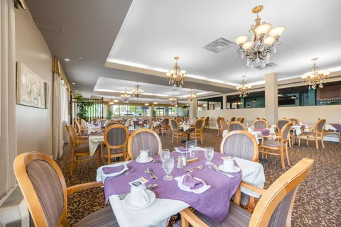 Dining room with set round tables and chandeliers.