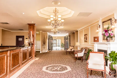 Entrance lobby with a reception desk, chandelier and seating.