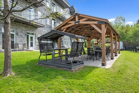 Wooden gazebo and garden seating beside the residence.