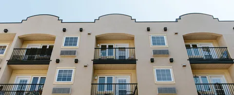 Upper floors of a cream-coloured residence with balconies