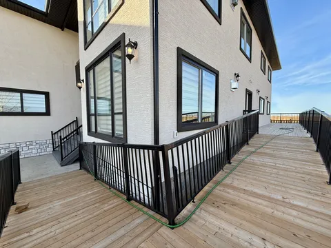 Wooden access ramp with black railings beside the building