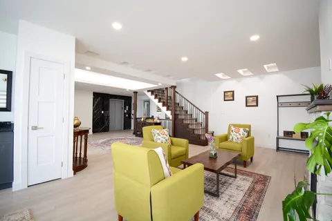Room with green armchairs, a coffee table, a staircase and a fireplace