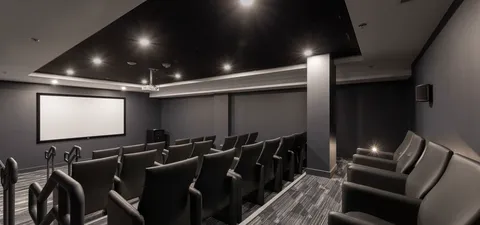 Cinema room with a blank screen and rows of reclining chairs