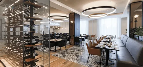 Dining room with tables, upholstered chairs and circular ceiling lights