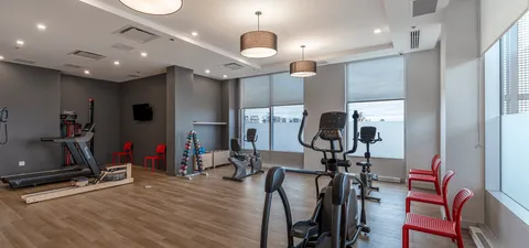 Fitness room with exercise machines and wooden flooring