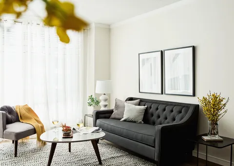 Suite living room with a dark sofa, armchairs and a coffee table.