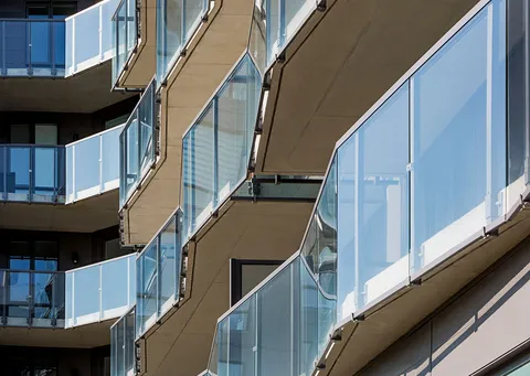 Close view of the residence facade and glass balcony railings.