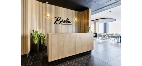 Bistro reception counter beside wood panelling and an open dining area