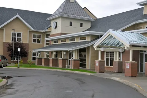 Covered building entrance beside a curved driveway