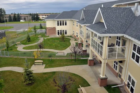 Building beside a courtyard with paths, lawns and benches