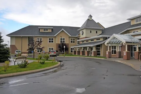 Two-storey building with a clock tower and covered entrance
